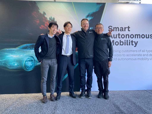 Four men standing in front of a Smart Autonomous Mobility display